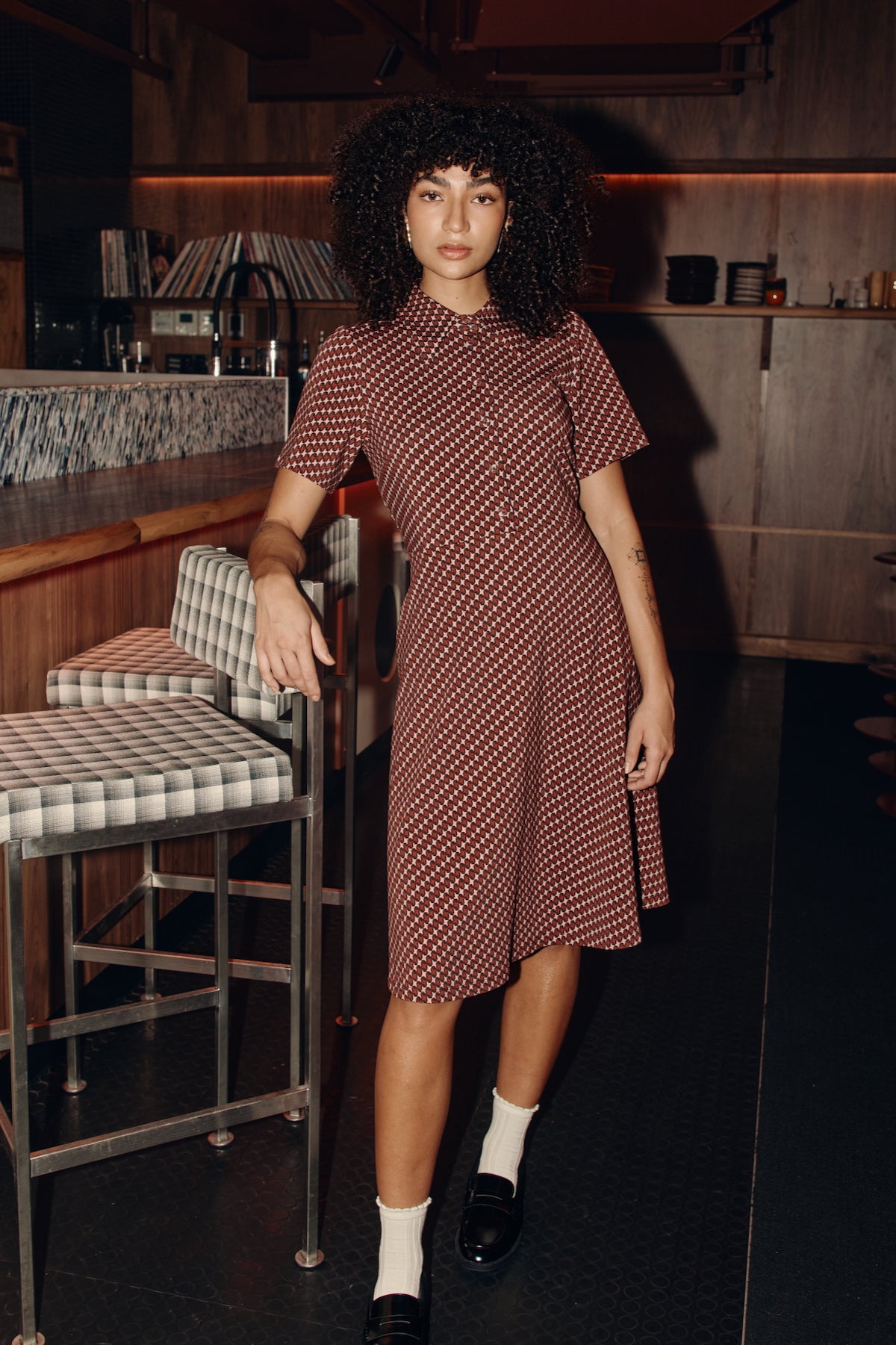 Girls standing at a bar wearing a Frock Me Out Retro Polo Dress with a burgundy pattern